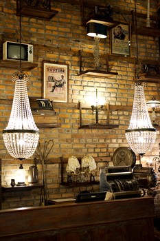 Cozy vintage interior with illuminated chandeliers and a brick wall backdrop.