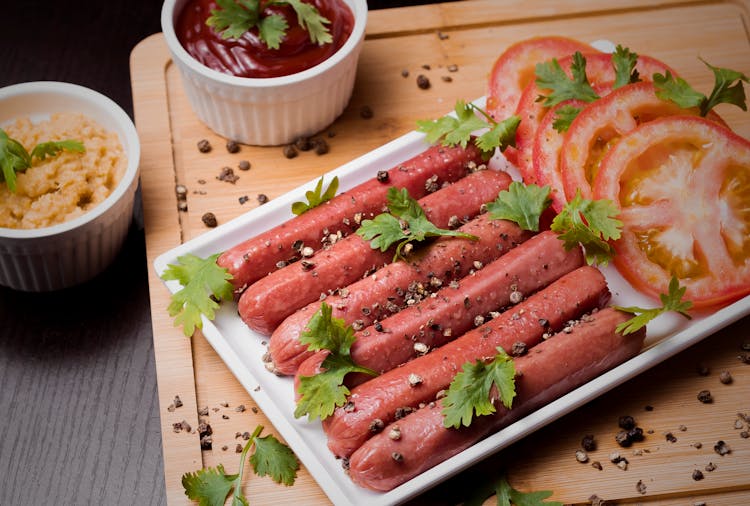 Frankfurter Sausages With Tomatoes On White Plate