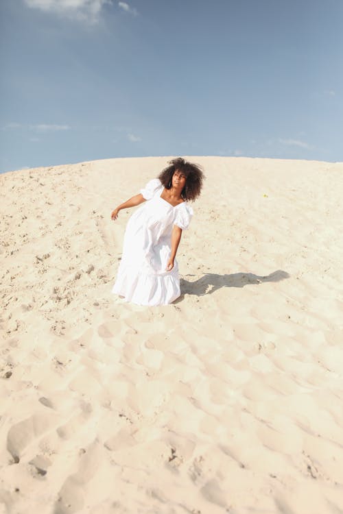 Woman Posing in White Dress Walking on Sand