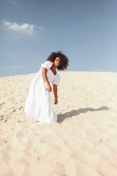 Woman in White Dress Standing on White Sand