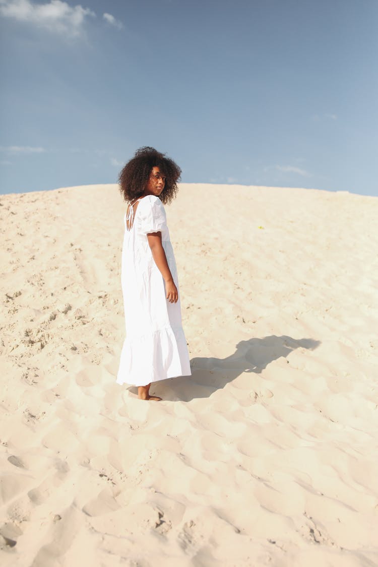 Woman In White Dress Walking On Sand