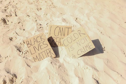 Messages on the Cardboards Placed on the Sandy Ground