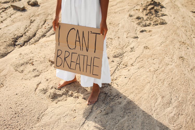 A Person In Long White Skirt Holding A Banner 