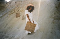 一名妇女站在沙漠中，举着“肤色不是犯罪”和“黑人的命也是命”的标语，倡导激进主义