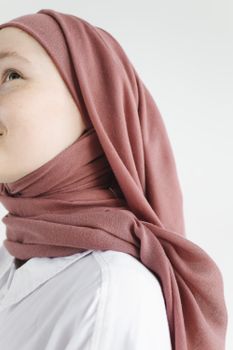 特写：一名戴着粉色头巾、背景为白色的年轻女子