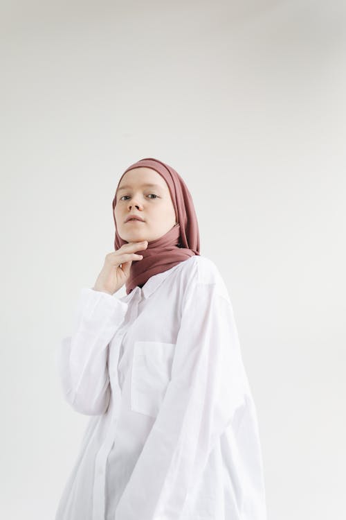 Young Woman Standing in White Long Sleeve Shirt and Brown Hijab