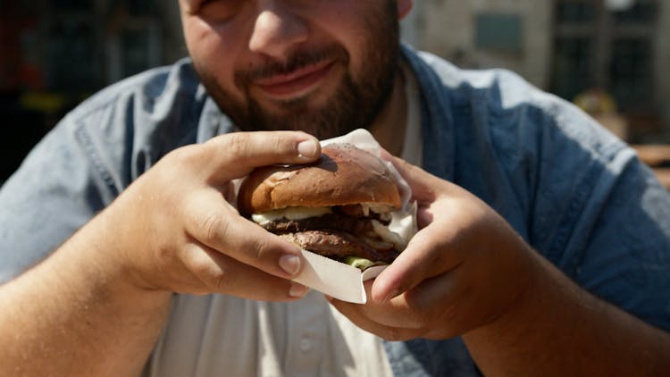 Bearded Man Holding A Burger With Patty