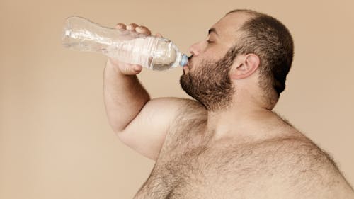 Free Man Drinking from Clear Plastic Bottle Stock Photo