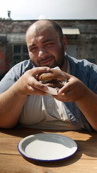 A man savoring a delicious hamburger at an outdoor setting in Australia.
