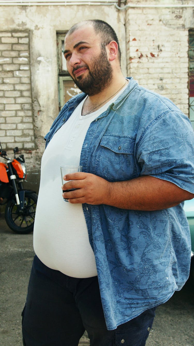 Man In Blue Button Up Shirt Holding A Glass Of Drink