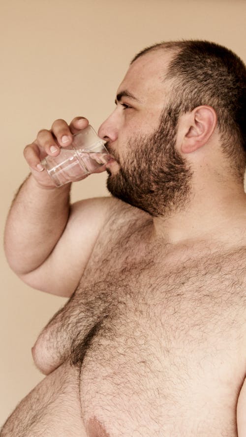 Topless Man Drinking Glass of Water
