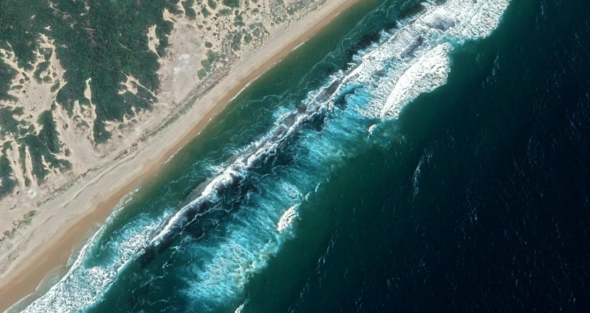 Stunning aerial view of the Mozambique coastline with clear turquoise waters and sandy beaches.