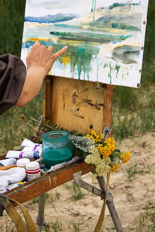 Painter drawing on canvas in countryside