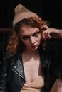 Woman in Black Leather Jacket Wearing Brown Knit Cap