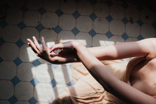 Free Elegant hands casting shadows on a tiled floor, creating an artistic and contemporary composition. Stock Photo