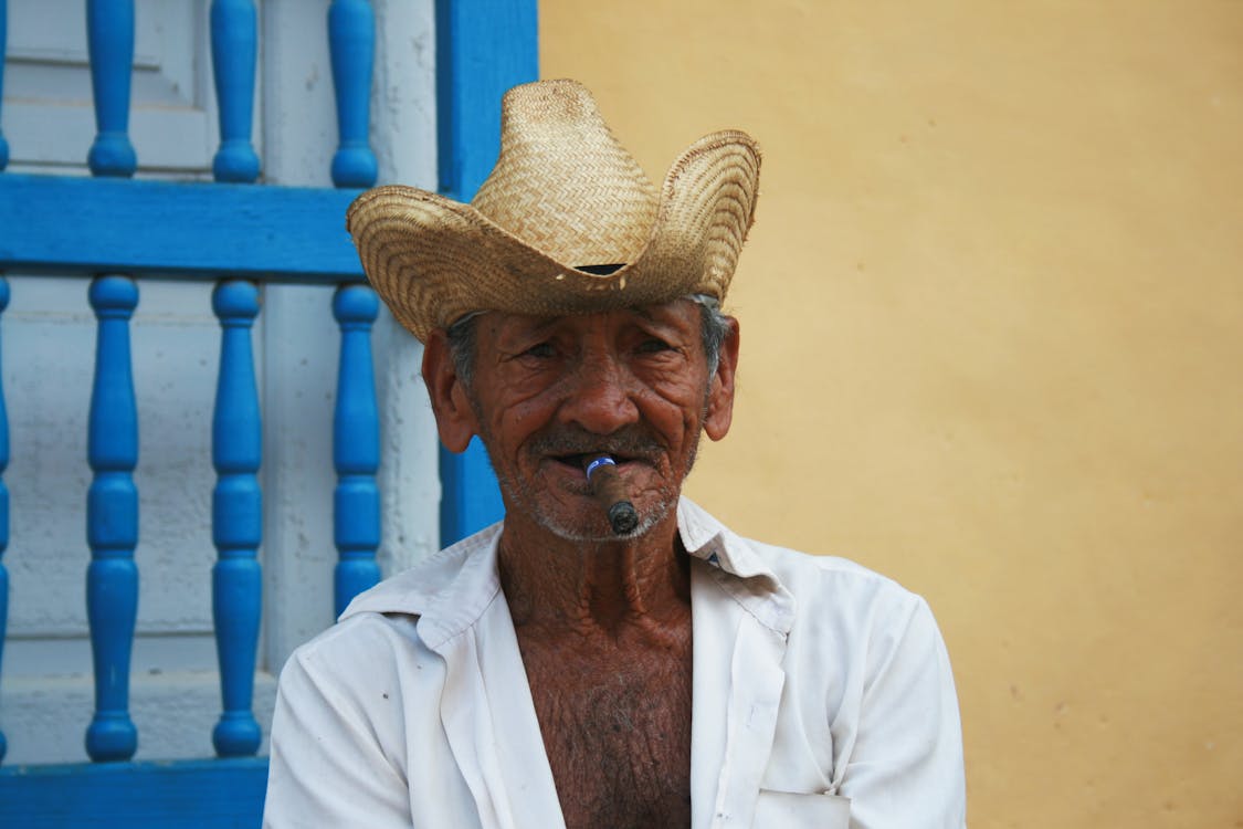 Man Wearing Straw Hat While Smoking