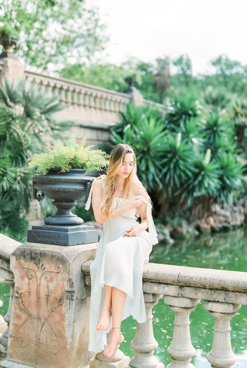 A Woman in White Dress Leaning on Concrete Stair Railing · Free Stock Photo