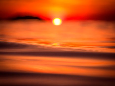 Stunning sunset view over the ocean in Arraial do Cabo, Brazil with vibrant orange hues.
