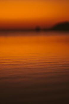 日落时分，海景朦胧而美丽，温暖的夕阳将生动色调映照在平静的水面上