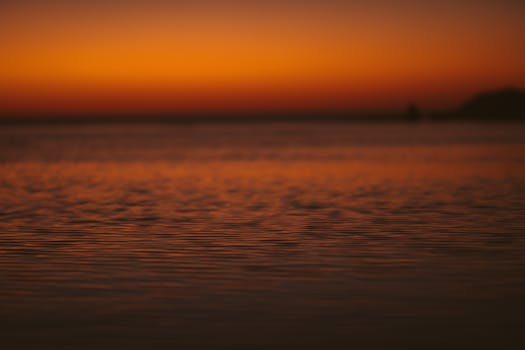 日落时分，海面平静，天空中洋溢着温暖而充满活力的色调