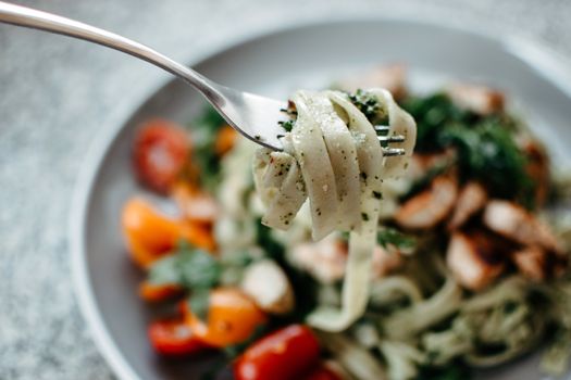 Close-up of a tasty pasta meal with cherry tomatoes and herbs, captured in a vibrant macro shot.