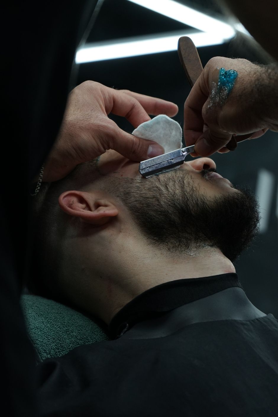 Barber expertly shaving a beard with a straight razor