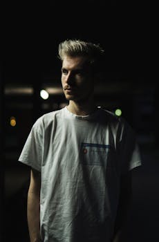 一个年轻人晚上穿着休闲服的戏剧性肖像，突出皮影戏和面部表情