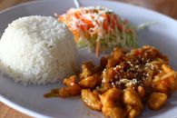 A Cup of Rice with a Delicious Pork and Coleslaw on a Plate