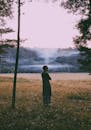 傍晚的阳光下，一个人站在明斯克一片宁静的田野上，背景是薄雾笼罩的森林