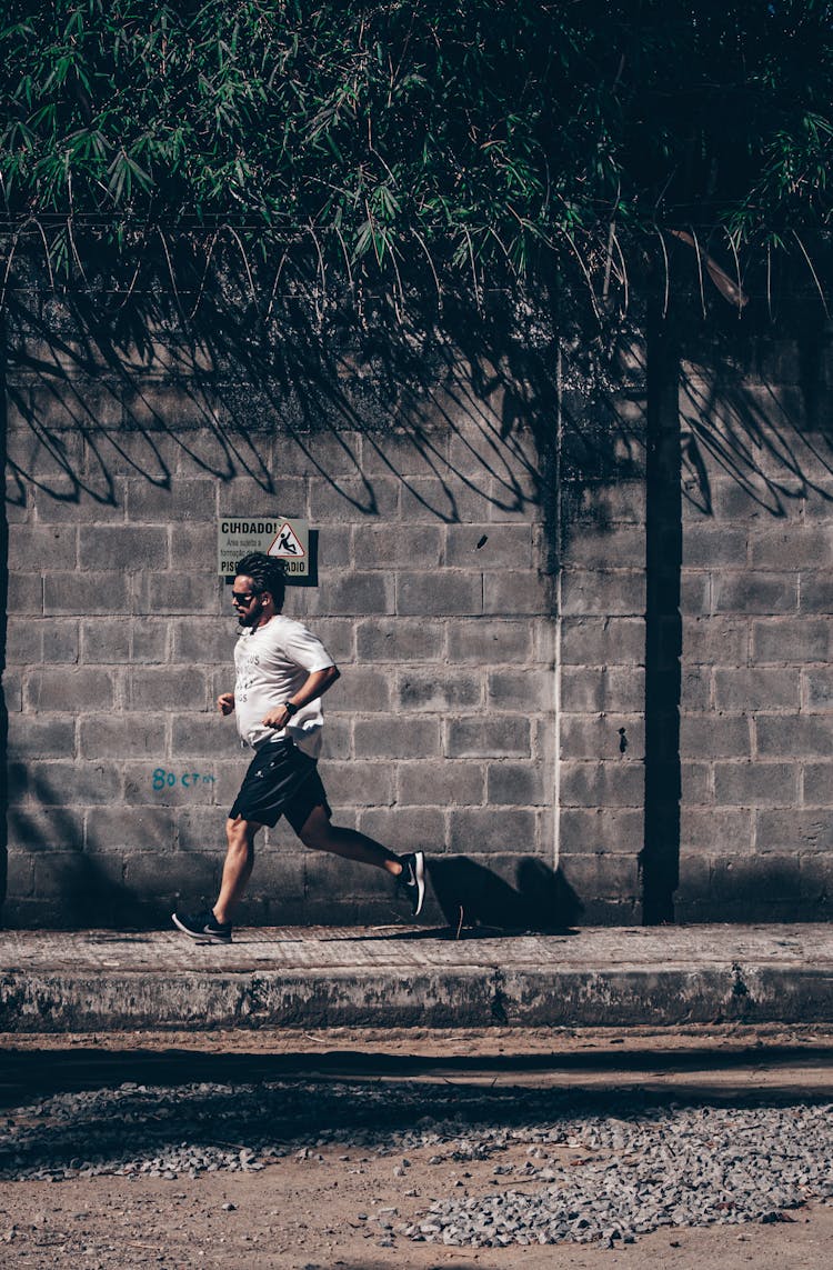 Concentrated Ethnic Man Jogging On Roadside