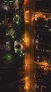 Aerial top view of modern suburban houses and empty asphalt road illuminated by electric lights at summer night