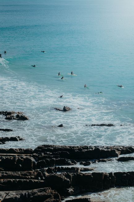A stunning aerial view of surfers enjoying the waves at Crescent Head Beach in New South Wales, Australia.