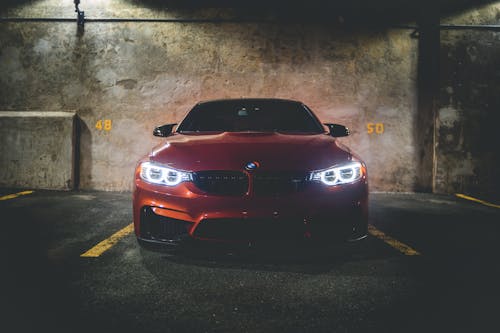 Red car in garage under flashlight