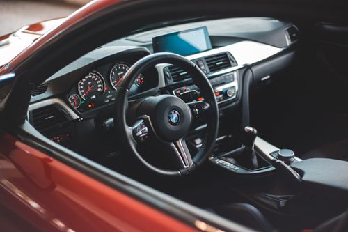 Free Comfortable cabin with modern steering wheel and panel in red car through opened window Stock Photo