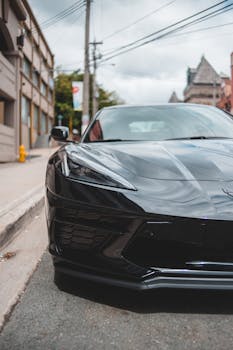 A luxurious black sports car parked on a city street showcasing its sleek design and modern aesthetics.