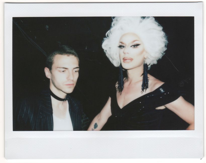 Vintage polaroid photo of a drag queen and a person at a nightclub party.