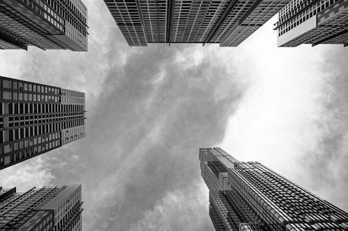 Monochrome Photo of Buildings under Cloudy Sky 