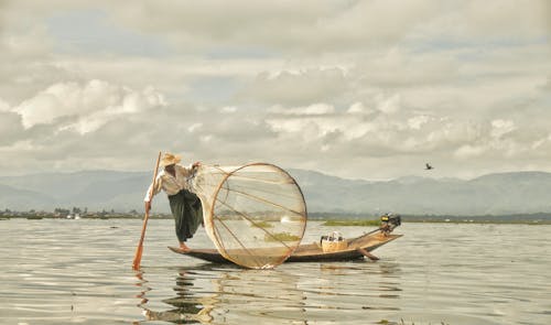 Free Fisherman Stanidng on the Edge of the Boat  Stock Photo