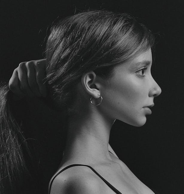 A striking black and white side profile of a woman holding her hair, photographed in Kyiv.