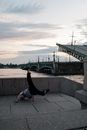 Woman in Black Long Sleeve Shirt and Blue Denim Jeans Sitting on Concrete Bench