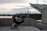 Man in Black T-shirt and Black Pants Sitting on Concrete Floor