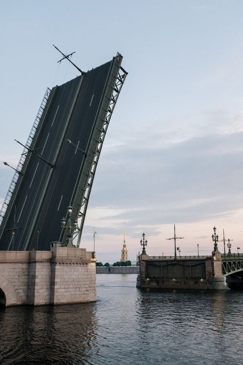 Free A cityscape with a dramatic drawbridge opening over the Neva River during the white nights in Saint Petersburg. Stock Photo