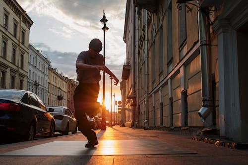 Man in Brown Shirt and Pants Playing Guitar on Street