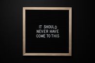 Wooden frame with IT SHOULD NEVER HAVE COME TO THIS text on center