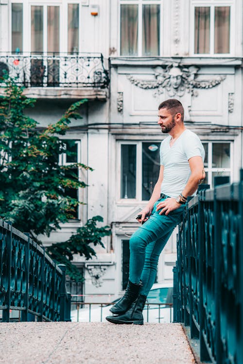 Handsome man leaning on old city bridge