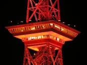 塔楼特写中，夜空中闪烁的红色灯光展示了建筑照明