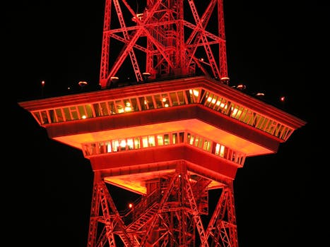 塔楼特写中，夜空中闪烁的红色灯光展示了建筑照明