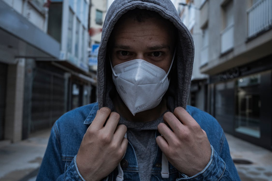 Person in Gray Hoodie and Denim Jacket Wearing Mask