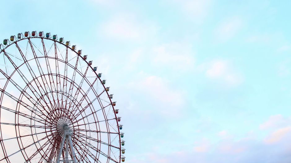 鮮やかな観覧車が澄んだ青空に向かってそびえ立ち、東京の遊園地の本質を捉えています。