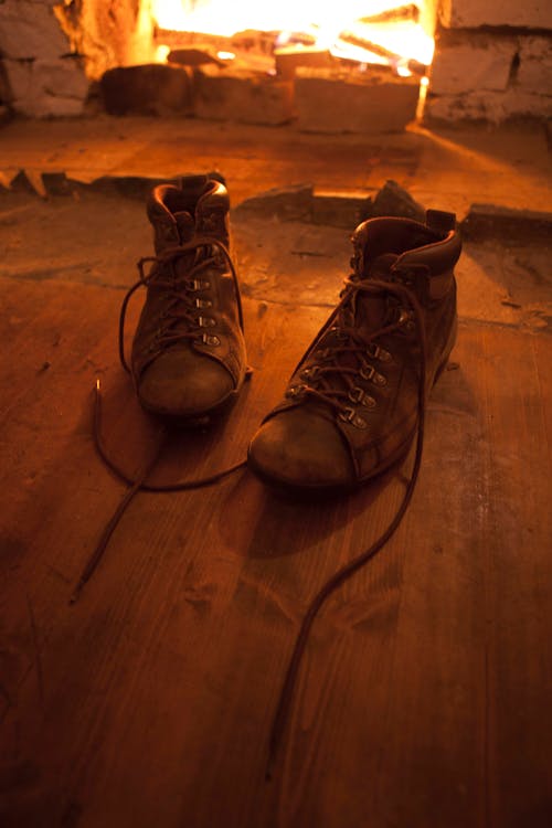 Brown Hiking Boots Near the Brick Fireplace